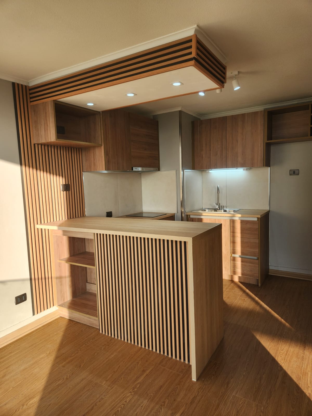 Cocina con isla de madera y detalles de listones